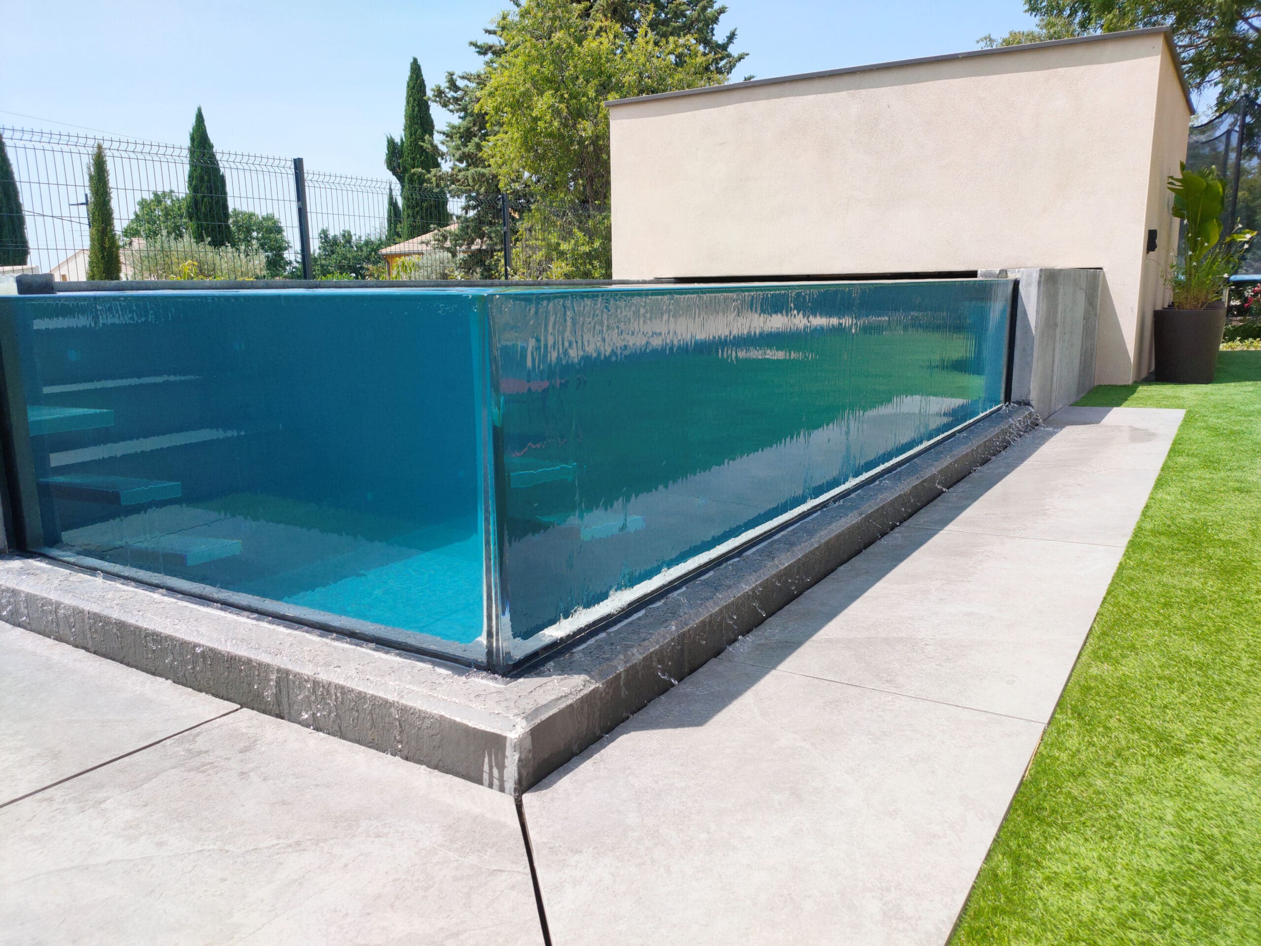 Piscine en verre à débordement en PVC armé.