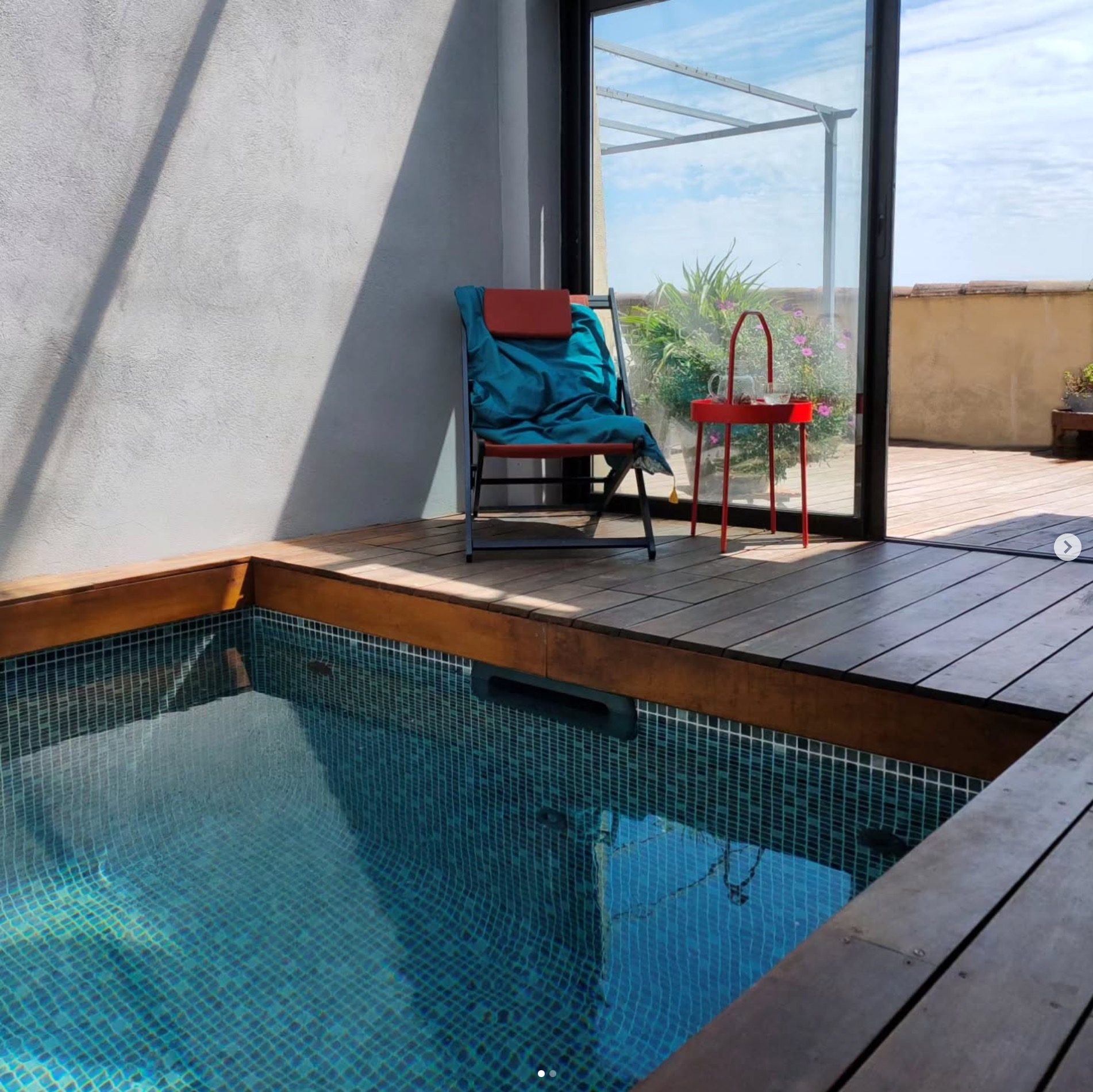 Mini piscine d'intérieur avec une terrasse en parquet massif et un coin détente.